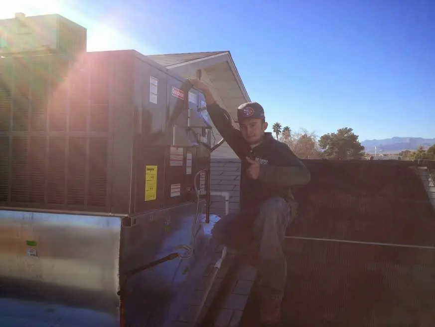 HVAC technician performing AC Tune-Up on a rooftop unit in Carlisle